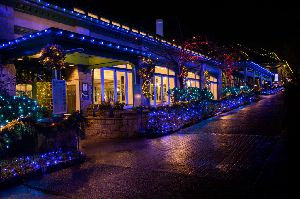The exterior of The Blue Poppy Restaurant and the pathway leading past the restaurant towards the information centre, decorated for the Christmas season.