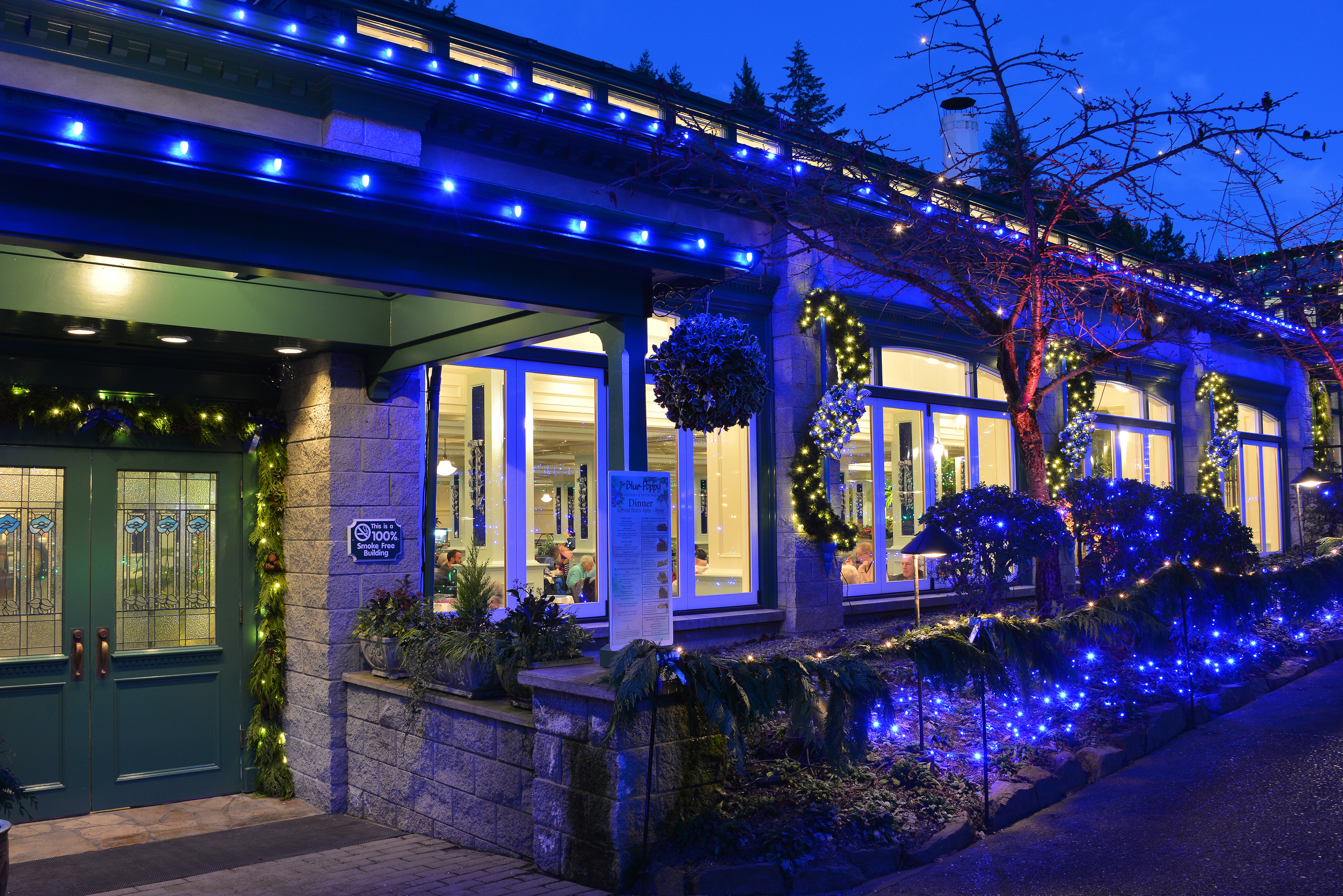Close up, side angle view of the entrance to The Blue Poppy Restaurant, decorated for the Christmas season.