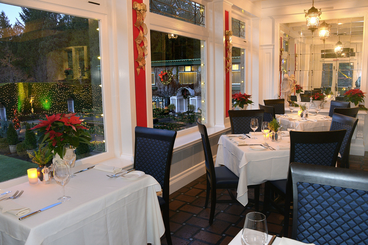 Interior view of table in the Dining Room Restaurant, decorated for Christmas time. The view the windows is the Italian Garden.