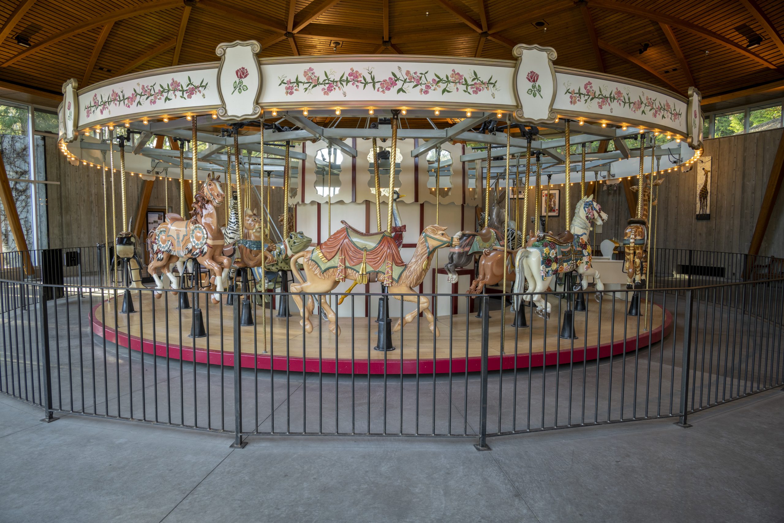 Indoor wooden carousel featuring 30 hand-carved wooden animals and two chariots.