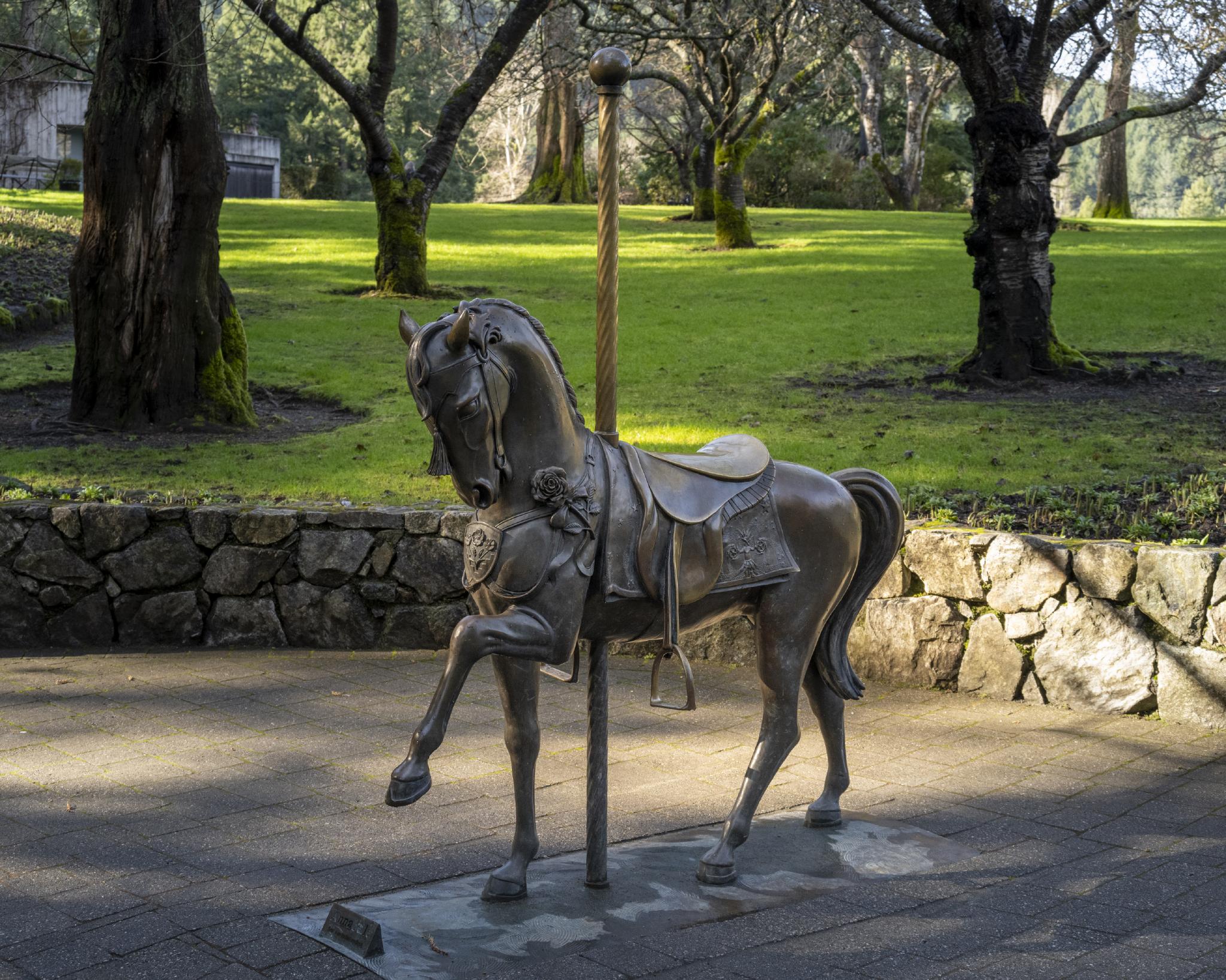 Bronze statue of a carousel house that people can sit on and take a photo at.